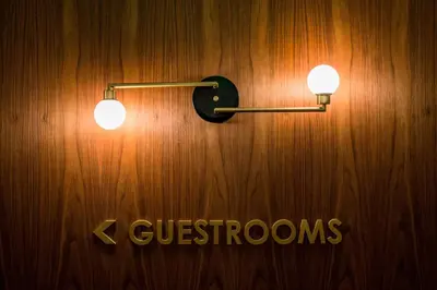 a wall with two lights on a wooden wall at The Dalmar, Fort Lauderdale, a Tribute Portfolio Hotel in Fort Lauderdale