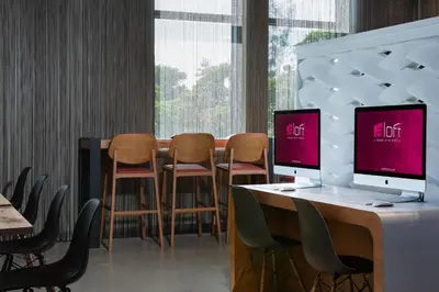 a room with chairs and a desk with a computer on it at Aloft Miami Aventura in Aventura