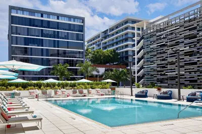 an image of a swimming pool with chairs and a building at Aloft Miami Aventura in Aventura