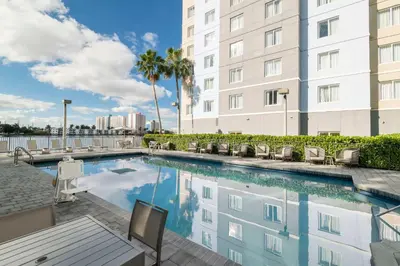 a swimming pool in front of a building at Homewood Suites Miami Airport/Blue Lagoon in Miami