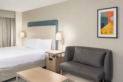 a hotel room with a bed and a chair at Homewood Suites Miami Airport/Blue Lagoon in Miami