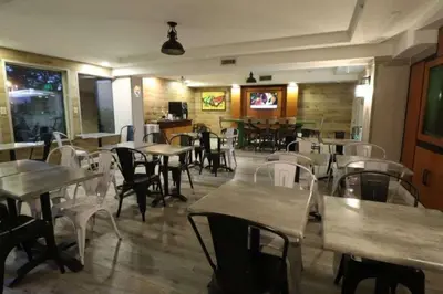 a restaurant with tables and white chairs and tables and chairs at Quality Inn Miami Airport - Doral in Miami