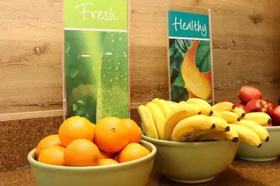 three bowls of fruit on a counter with oranges and bananas at Quality Inn Miami Airport - Doral in Miami