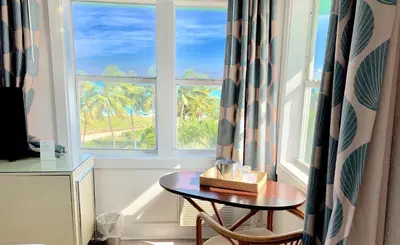 a table and a chair in a room with a window at Broadmore Miami Beach in Miami Beach