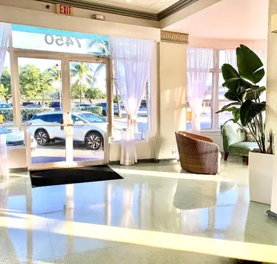 a living room with a glass door with a car outside at Broadmore Miami Beach in Miami Beach