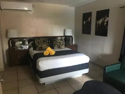 a bedroom with a bed with a yellow object on it at INN LEATHER GUEST HOUSE-GAY MALE ONLY in Fort Lauderdale