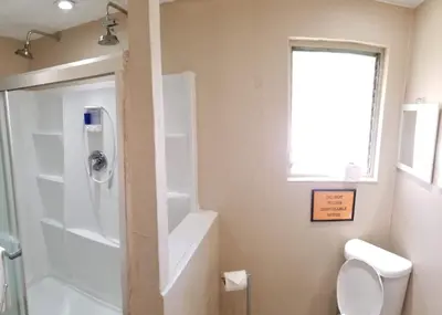 a bathroom with a shower and a toilet and a window at INN LEATHER GUEST HOUSE-GAY MALE ONLY in Fort Lauderdale