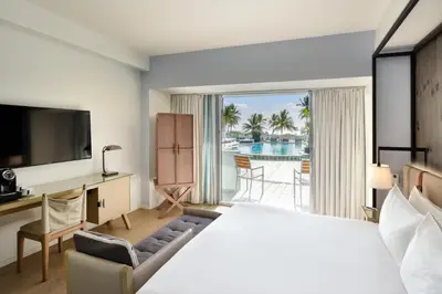 a hotel room with a bed and a desk and a television at Hotel Victor South Beach in Miami Beach