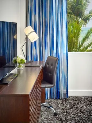 an office with a desk and a chair in front of a window at Sonesta Fort Lauderdale Beach in Fort Lauderdale