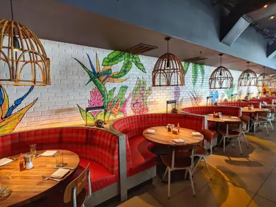 a restaurant with red seats and a colorful wall at 1201 W Residences in Fort Lauderdale