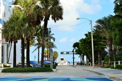 a street with palm trees and a traffic light at 1201 W Residences in Fort Lauderdale