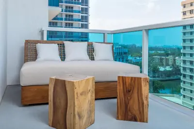 a bedroom with a bed and two log stools at Oceanview Private Condo at 1 Hotel & Homes -915 in Miami Beach