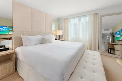 a bedroom with a large white bed and a living room at Oceanview Private Condo at 1 Hotel & Homes -1208 in Miami Beach