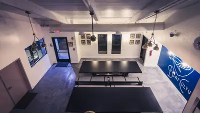 a room with a table and benches in it at enVision Hotel Miami International Airport in Miami