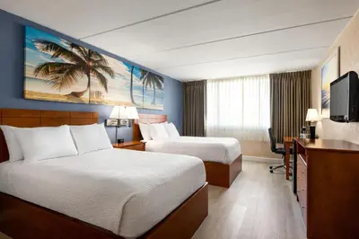 a hotel room with two beds and a television at enVision Hotel Miami International Airport in Miami