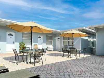 a patio with tables and chairs and umbrellas at Silver Spray Motel in Hollywood