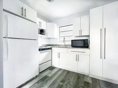 a white kitchen with white appliances and white cabinets at Silver Spray Motel in Hollywood