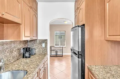 a kitchen with wooden cabinets and a stainless steel refrigerator at Silver Spray Motel in Hollywood