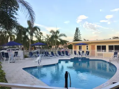 a swimming pool at a resort with blue chairs at Curtis Inn & Suites in Hollywood