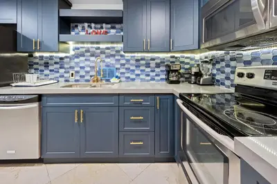 a kitchen with blue cabinets and a stove top oven at Alquiler temporario Miami in Hollywood
