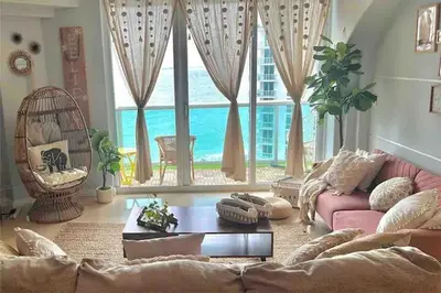 a living room with a couch and a large window at Alquiler temporario Miami in Hollywood