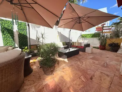 an outdoor patio with two large umbrellas and plants at Sinclair Boutique Hotel in Hollywood