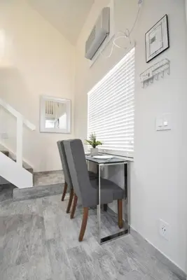 a dining room with a table and a chair at Modern Loft wQueen Loft Steps to Beach in Hollywood