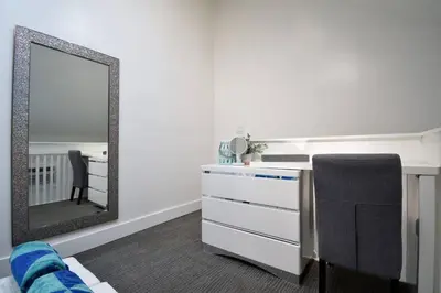 a bedroom with a mirror and a desk with a chair at Modern Loft wQueen Loft Steps to Beach in Hollywood