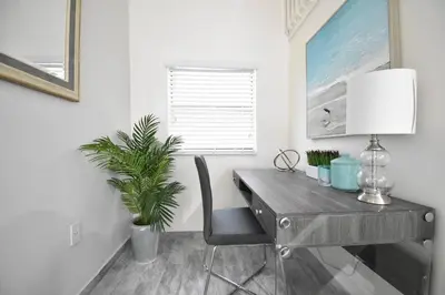 a desk with a lamp and a plant in a room at Lofted Apt wQueen Loft Nook steps to Beach in Hollywood