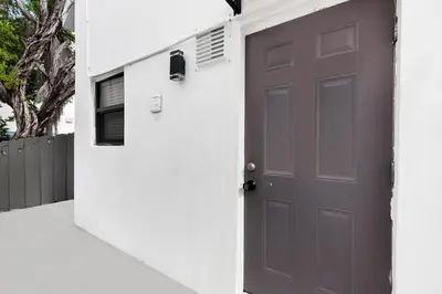 a gray door in a white wall with a house at Lofted Apt wQueen Loft Nook steps to Beach in Hollywood