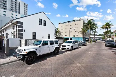 a white jeep parked on the side of a street at Lofted Apt wQueen Loft Nook steps to Beach in Hollywood