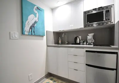 a kitchen with a microwave and a bird painting on the wall at Modern Loft wBed Steps from Beach Boardwalk in Hollywood