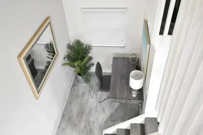 a stairway with a mirror and a table in a room at Modern Loft wBed Steps from Beach Boardwalk in Hollywood