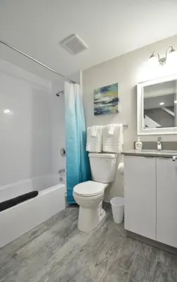 a bathroom with a toilet and a tub and a sink at Modern Loft wQueen Loft Steps to Beach in Hollywood