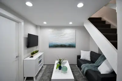 a living room with a couch and a staircase at Loft wqueen loft beach steps in Hollywood