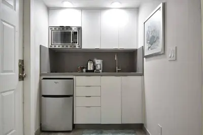a kitchen with white cabinets and a microwave at Loft wqueen loft beach steps in Hollywood