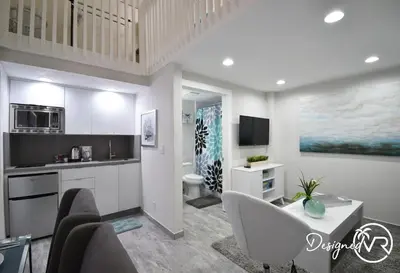 a kitchen with a living room with a couch and a table at Loft wqueen bed steps to Hollywood Beach in Hollywood
