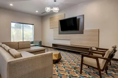 a living room with a couch and a flat screen tv at Comfort Suites Fort Lauderdale Airport & Cruise Port in Dania Beach