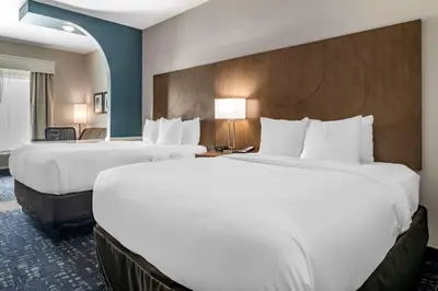 two beds in a hotel room with white sheets at Comfort Suites Fort Lauderdale Airport & Cruise Port in Dania Beach