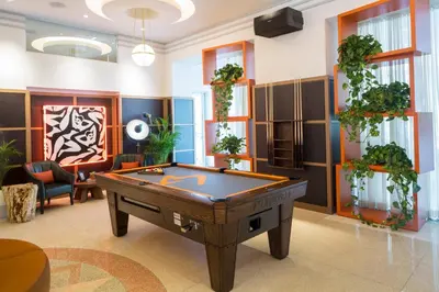 a pool table in a room with plants at Generator Miami in Miami Beach