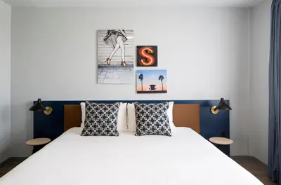 a bedroom with a large white bed with two tables at Generator Miami in Miami Beach
