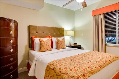 a bedroom with a bed and a dresser and a window at Sun Harbour Boutique Hotel in Miami Beach