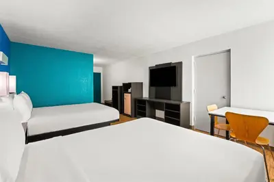 a hotel room with two beds and a tv at Signature Inn Miami in Miami
