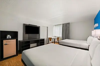 a hotel room with two beds and a flat screen tv at Signature Inn Miami in Miami