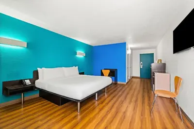 a large bed in a room with a blue wall at Signature Inn Miami in Miami