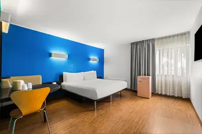 a hotel room with a bed and a blue wall at Signature Inn Miami in Miami