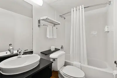 a white bathroom with a sink and a toilet at Signature Inn Miami in Miami