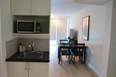 a kitchen with a sink and a table with chairs at New Point Miami Beach Apartments in Miami Beach