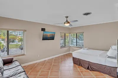 a bedroom with a bed and a couch and windows at Hollywood Beach Hotels in Hollywood