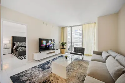 a living room with a couch and a tv at Icon Brickell Residences in Miami
